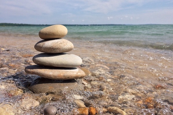 pile of balanced rocks by water's edge for ending procrastination