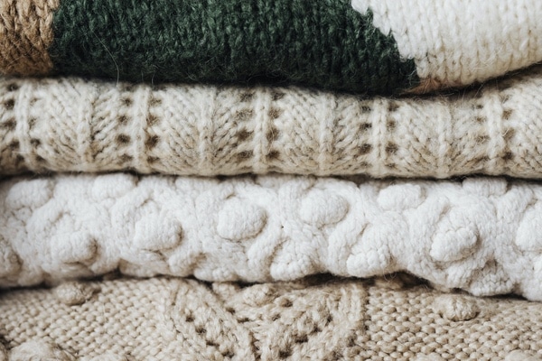 close up view of stack of knitted sweaters representing sweatering the memories