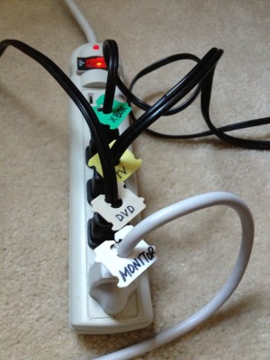 computer cords plugged into outlet labelled with bread bag tags