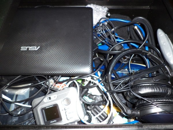 junk drawer full of electronics and spaghetti cords