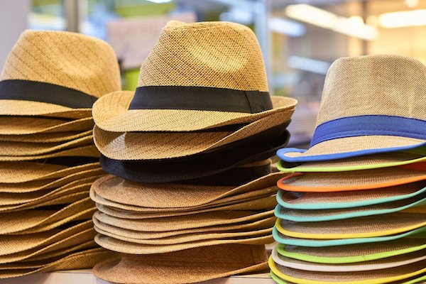 stacks of hats on table representing business owner wearing all the hats