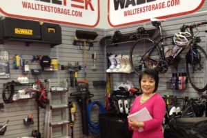Linda Chu standing in front of Walltek storage system where all items are hung on the wall showing how to go vertical with storage