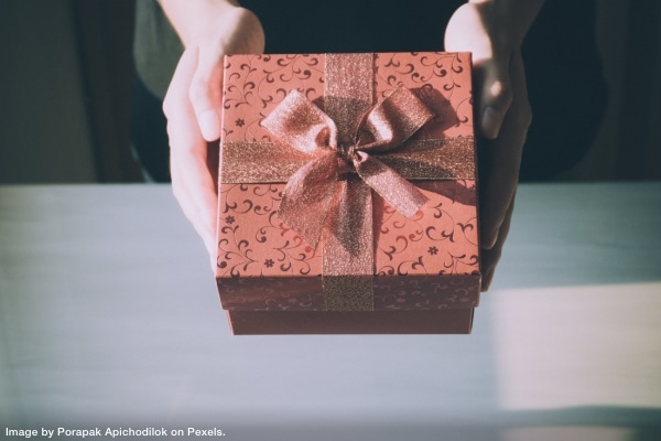 person holding a decorated box representing gift you don't want