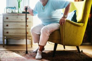 person using a cane to get up out of chair representing smart strategies to age-proof your home