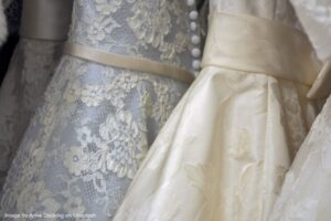 Close up of wedding dresses hanging on rack.