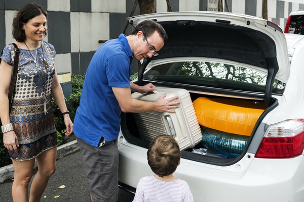 family beside car packing the trunk