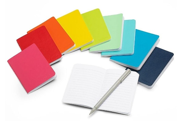 rainbow of paper planner notebooks with pen