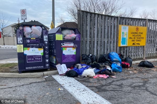 overflowing charity bins in parking lot with more donated items on the ground showing poor donation etiquette