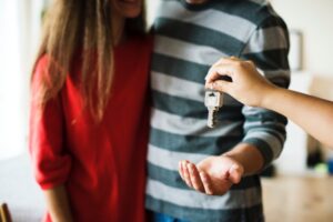 couple moving in together accepting house key from realtor
