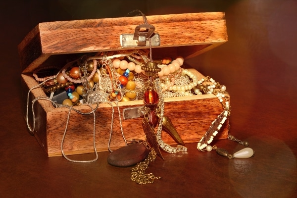 wooden box overflowing with jewelry representing a treasure hunt to make downsizing fun