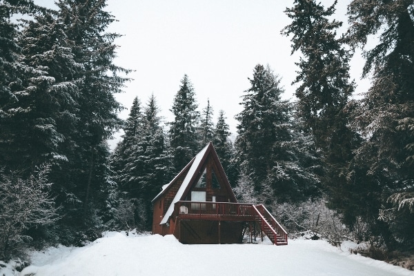 small a-frame cabin in the snowy woods representing organizing the cottage