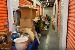 An Out of Chaos team member is sorting through items spread out in a hallway as they clear out a storage unit