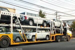 sport utility vehicles loaded on an auto-carrier truck representing ship your car when moving