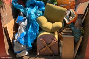 dumpster full of unwanted furniture and household items representing the costs of downsizing