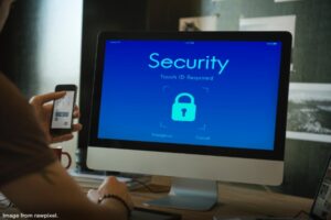 person sitting at computer with screen showing a big padlock and the word security representing safeguard digital assets of your business