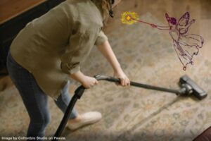 person vacuuming with fairy hovering above representing spring cleaning myths