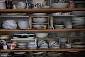 shelving unit with every shelf packed high with dishes - an example of what you need to downsize at your parents' house